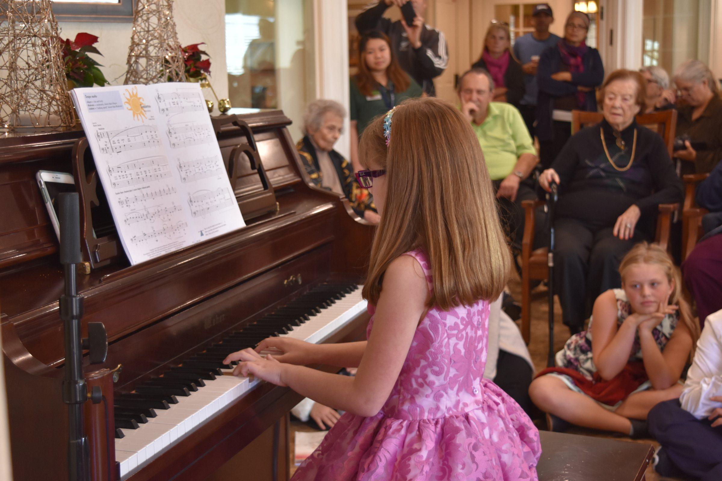 A piano student sharing music at home with family listening